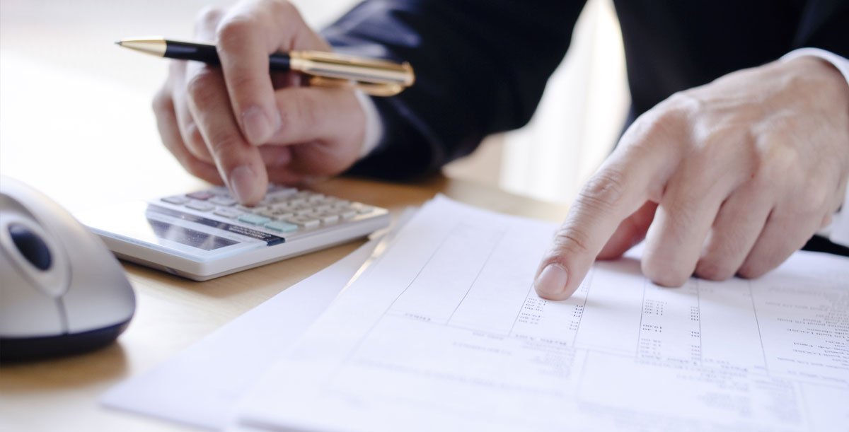 Mortgage broker reviewing rate paperwork with a calculator